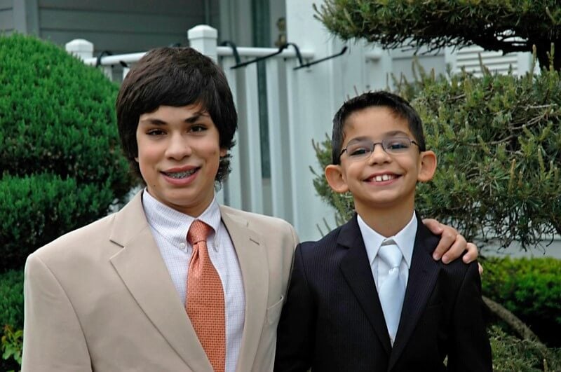 Photo of two young boys, dressed up in suits and ties, affected by Fragile X.