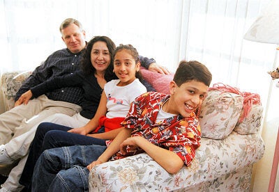 Family of four all sitting on their sofa