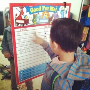 A child working with a visual schedule on an easel.