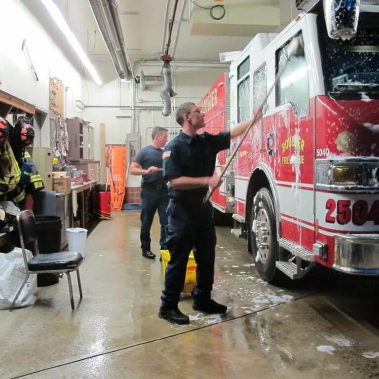 Ian washing the local fire truck with one of the firefighters.