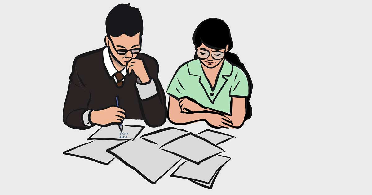 A couple looking at papers on a table with worrying looks.