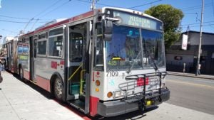 A public bus at the street curb.