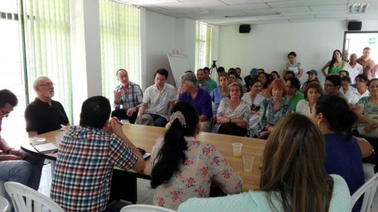 Project team members meeting with community leaders and medical officials in a large room in Bolivar.