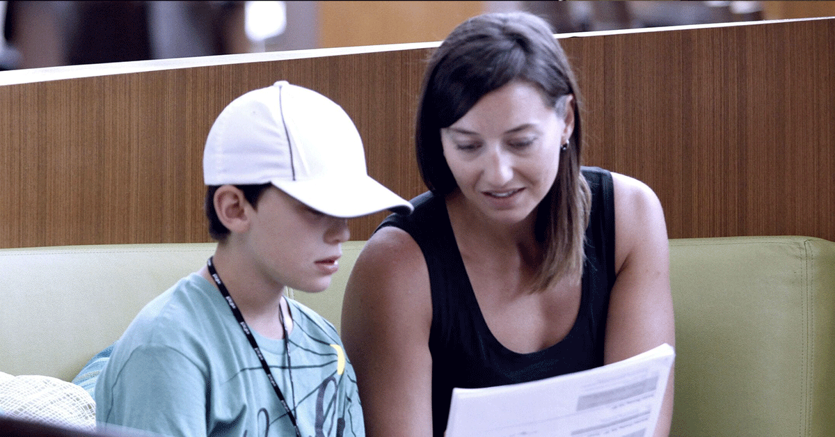 A mother and her son reading a document.