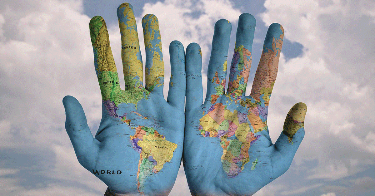 Two hands, palms facing forward, with the world map painted across both hands.