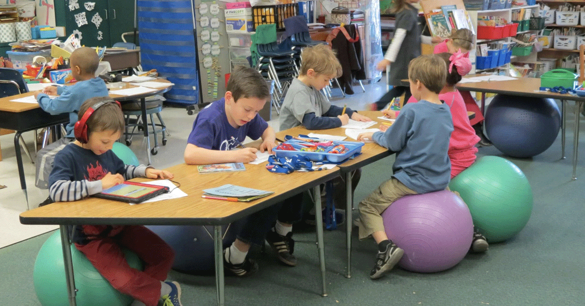 Young students at school at a work table.