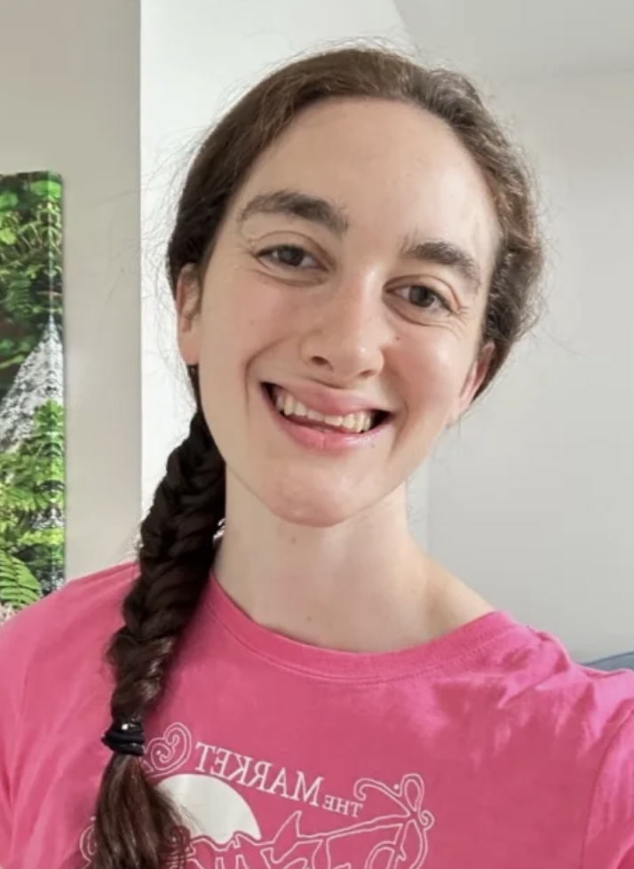 A girl wearing a pink t-shirt smiling