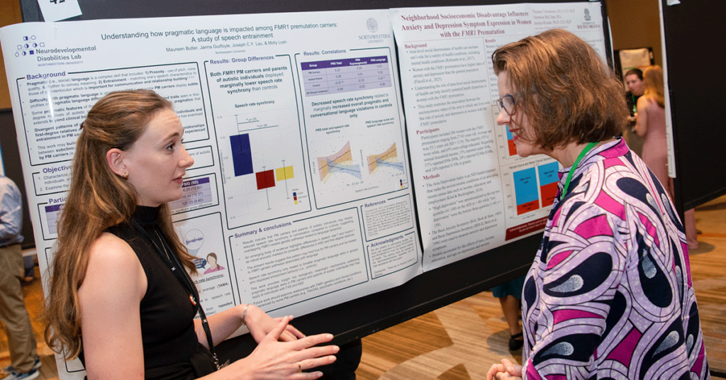 A young researcher during the poster sessions discusses pragmatic language with an attendee.