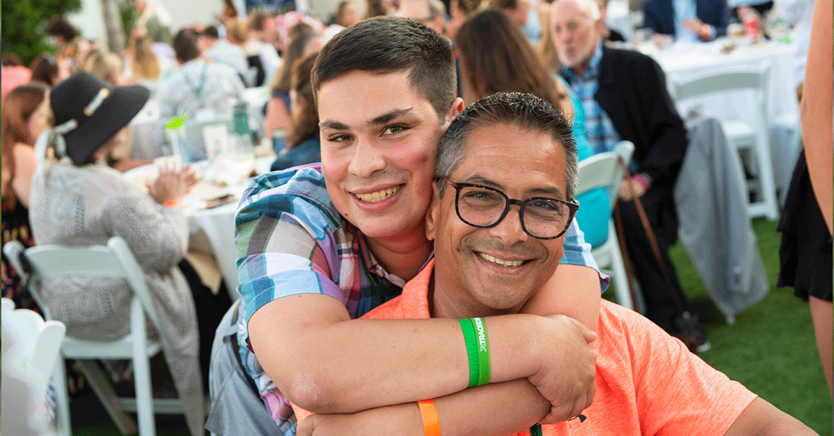 A teen hugging his father.