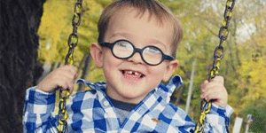 Young boy with FXS on a swing.