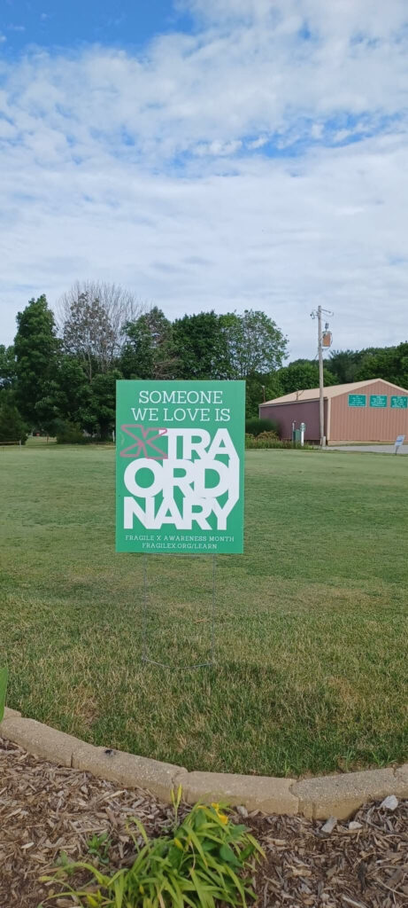 A lawn sign that reads Someone We Love Is Xtraordinary.