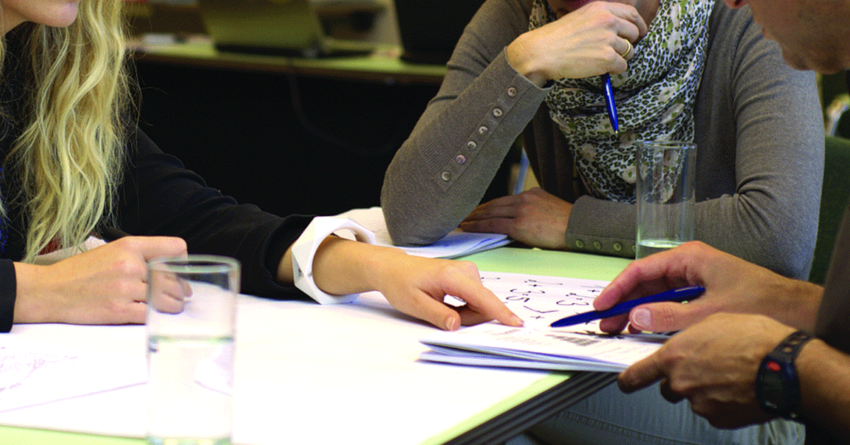 People discussing a report at a table.