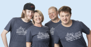 A family of a mom, dad, and two young adult sons. All wearing NFXF conference t-shirts.