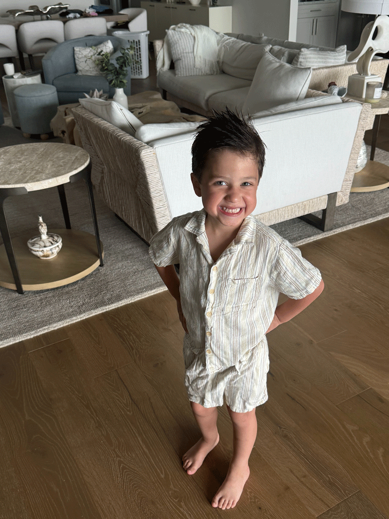 Cooper Schatz in his living room looking absolutely adorable smiling in his pajamas.