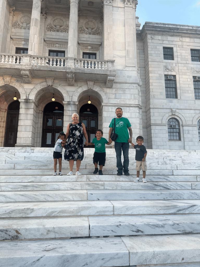 A family and Little Rhody Warriors members on the steps of the Rhode Island State House for Fragile X Awareness Day.