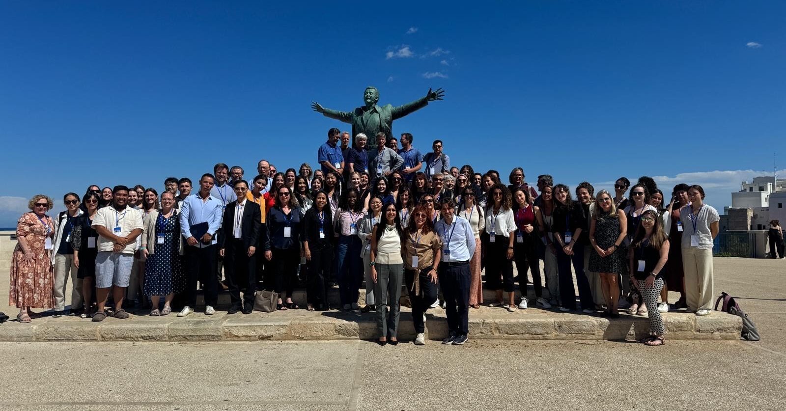 A large group of people standing in front of statue