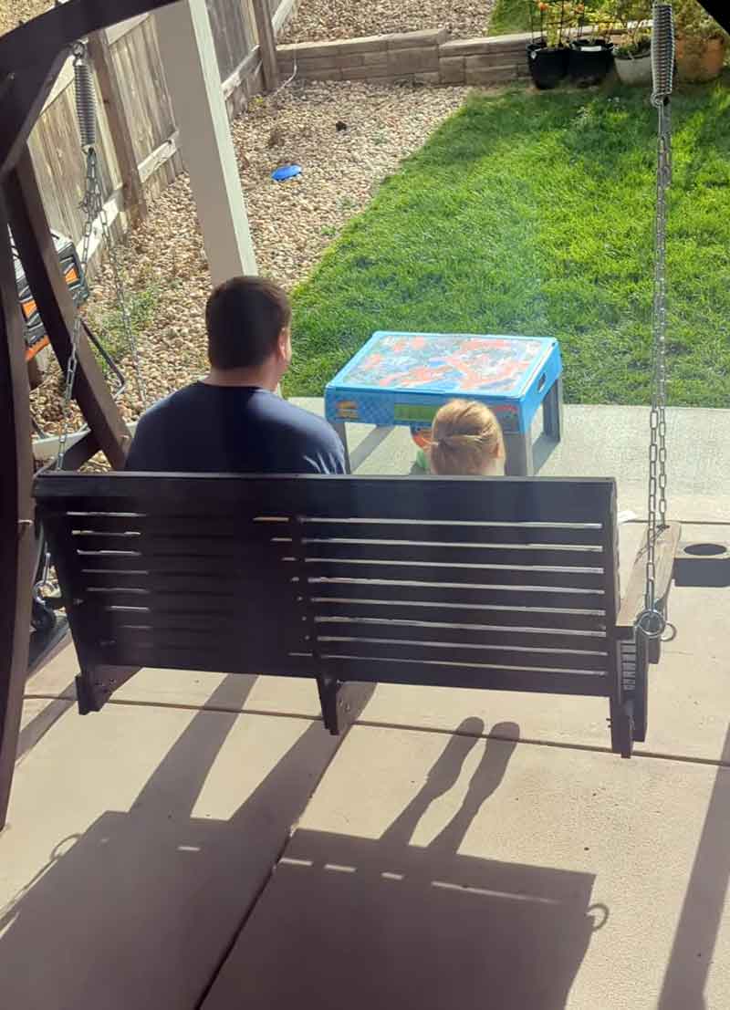 John Hebdon on a porch swing with his niece, both giggling uncontrollably. Adorable!