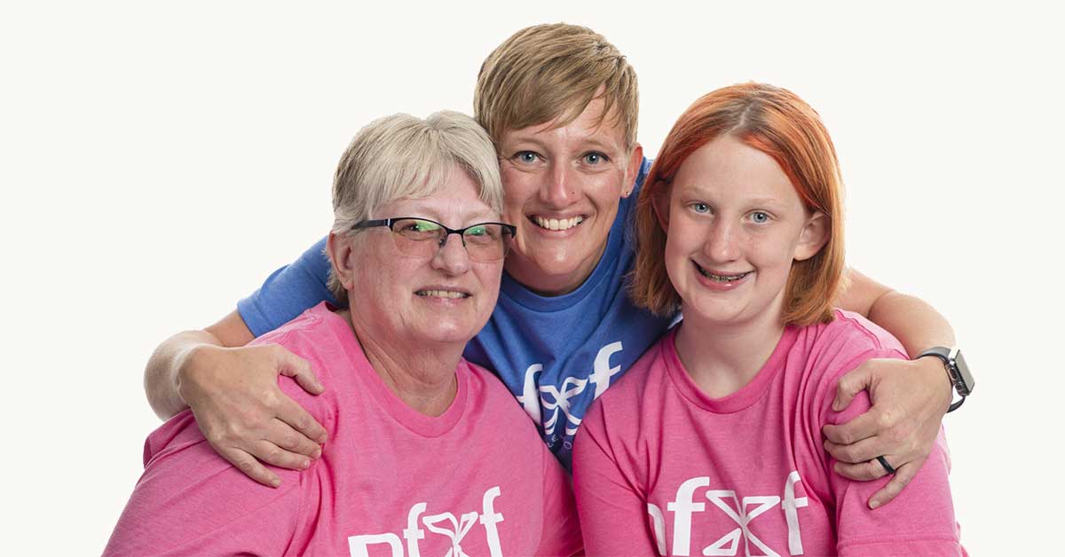 Three generations of women, wearing pink and blue NFXF tees.