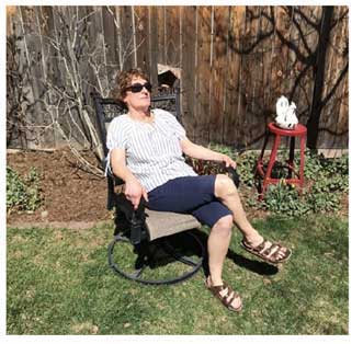 Jayne Dixon Weber in a lawn chair in her backyard, taking in the sunshine.