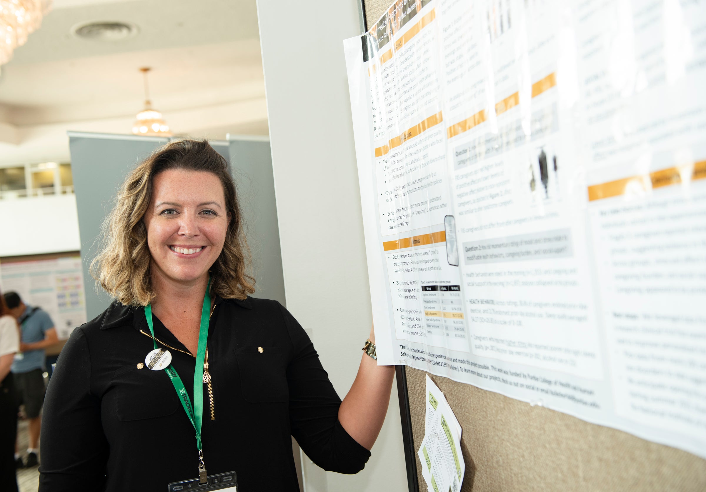 A researcher presenting her poster at conference