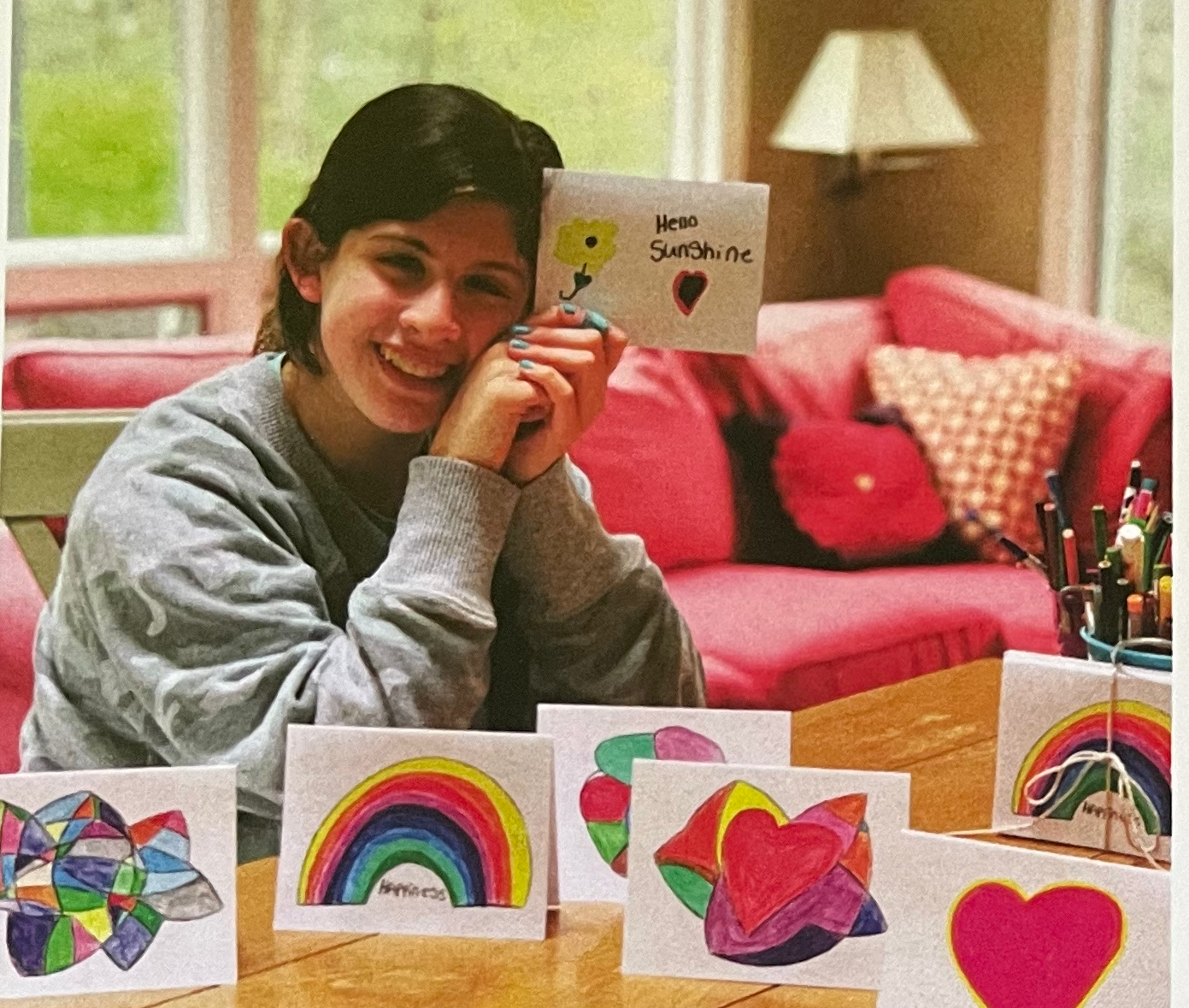 Artist pictured with a display of her drawings made into art cards