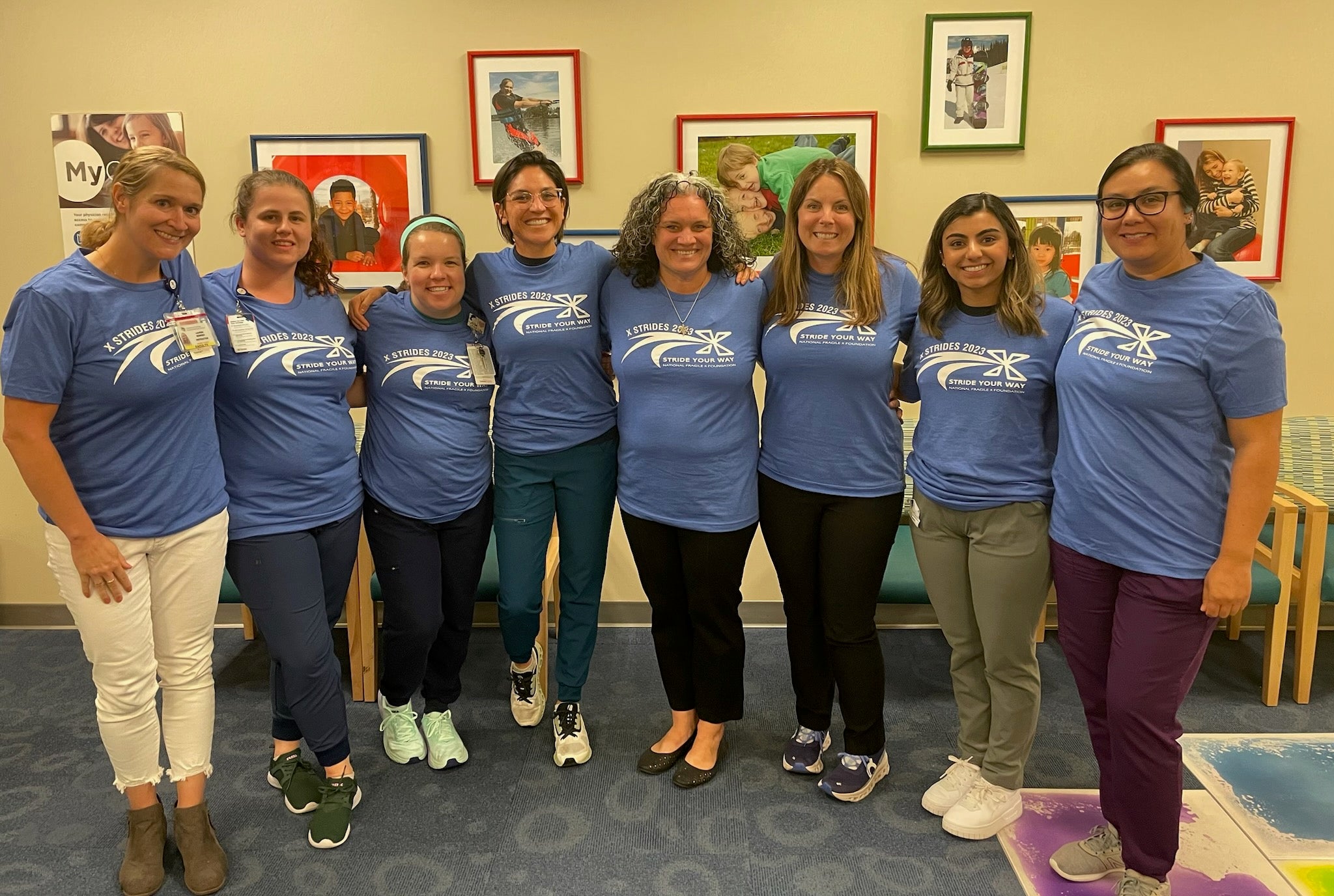 A group of clinic staff wearing blue NFXF X Strides t-shirts