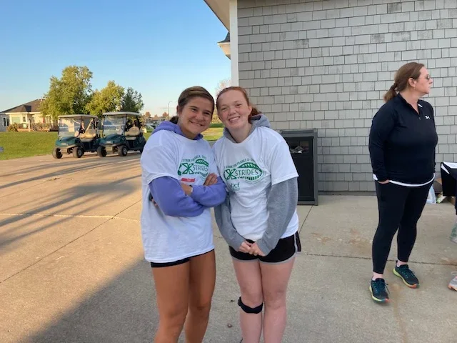 Two teenage girls participating in a Fragile X syndrome X Strides run/walk event and fundraiser.