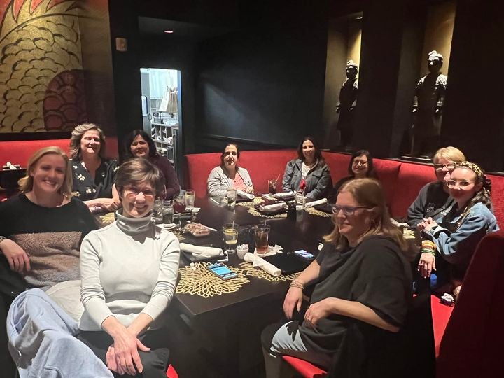 A group of parents sitting at a table in a restaurant