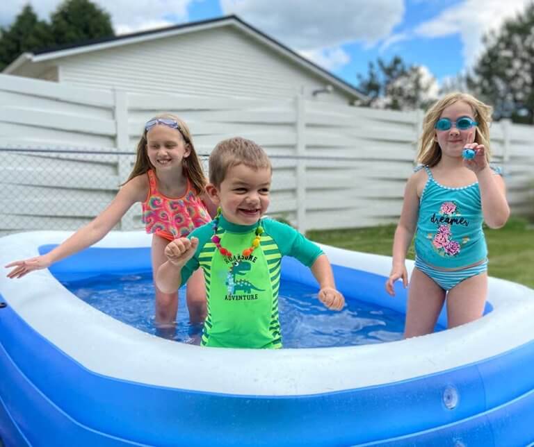 Paige & Mae Otterson in the kiddie pool with their Fragile X superhero brother.
