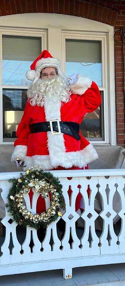 Andrew Pritchard on his porch in his Santa costume for Christmas.