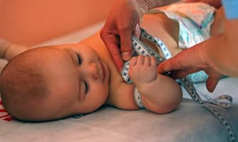 Baby being measured with a measuring tape