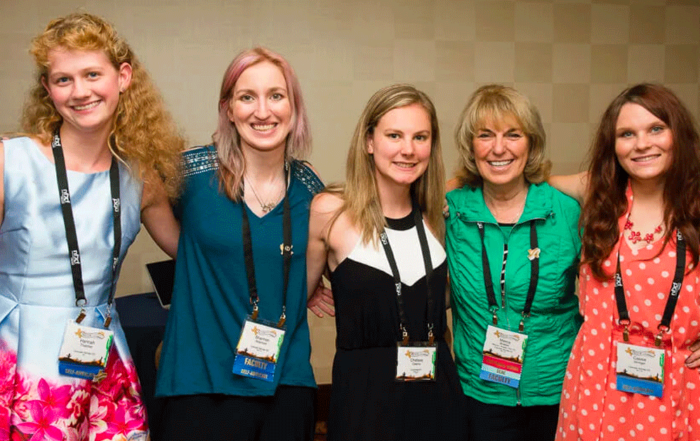 Dr. Braden and 4 females all wearing lanyards, attending the International Fragile X Conference.