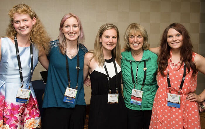 Dr. Braden and 4 females all wearing lanyards, attending the International Fragile X Conference.