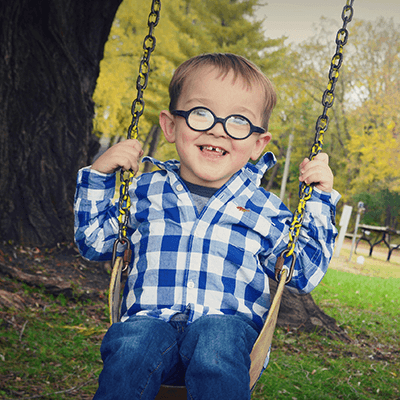 Young boy on a tree swing.