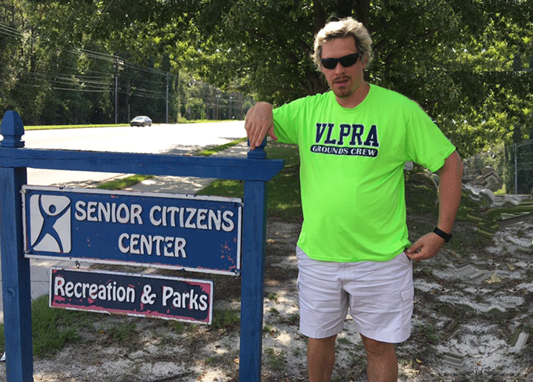 Clay Doub standing next to a Senior Citizens Center sign outdoors