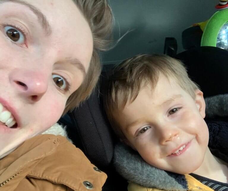 Eppie with her son who's seated in a car seat.