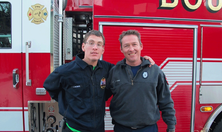Ian with a local firefighter with one of their fire trucks.