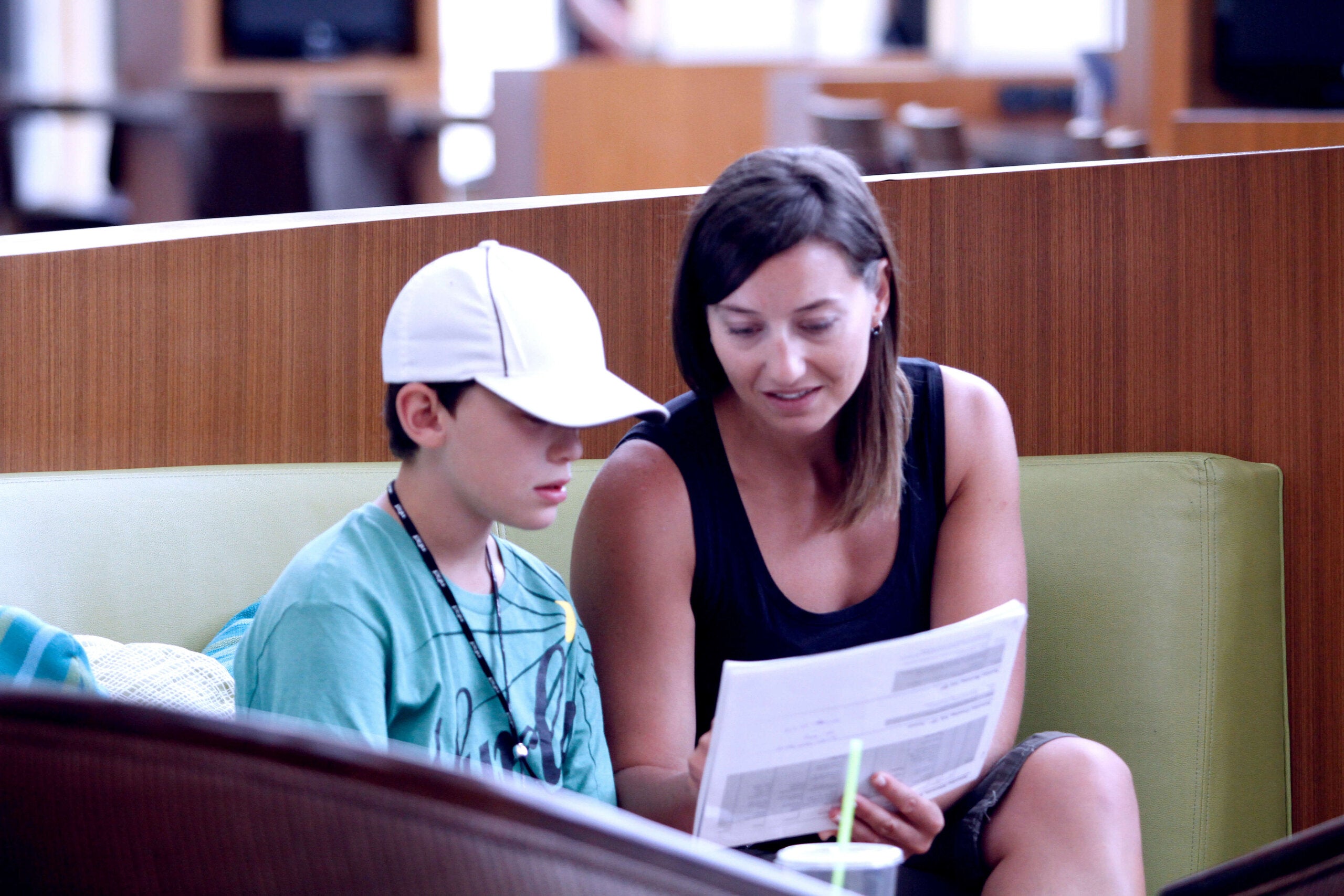 A woman and a young boy sitting on a sofa going over the Fragile X Conference schedule