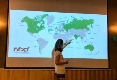 world map on screen with countries in green that attended the NFXF International Fragile X Conference. Speaker is pointing at Georgia