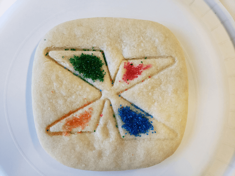 Cookie decorated with imprint of NFXF X logo and colored sprinkles