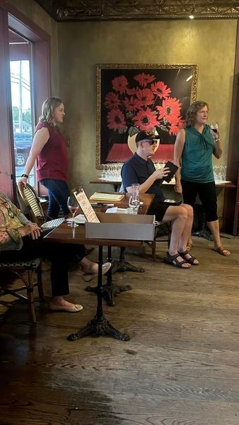 Guests drink wine and watch the silent auction at the Esselon Cafe.