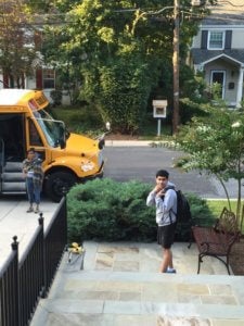 boy leaving home to get on a school bus