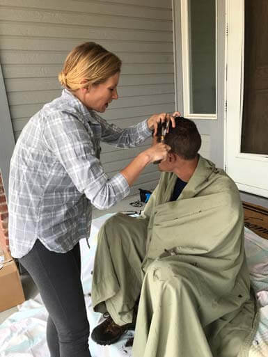 Ian's sister cutting his hair on the porch.