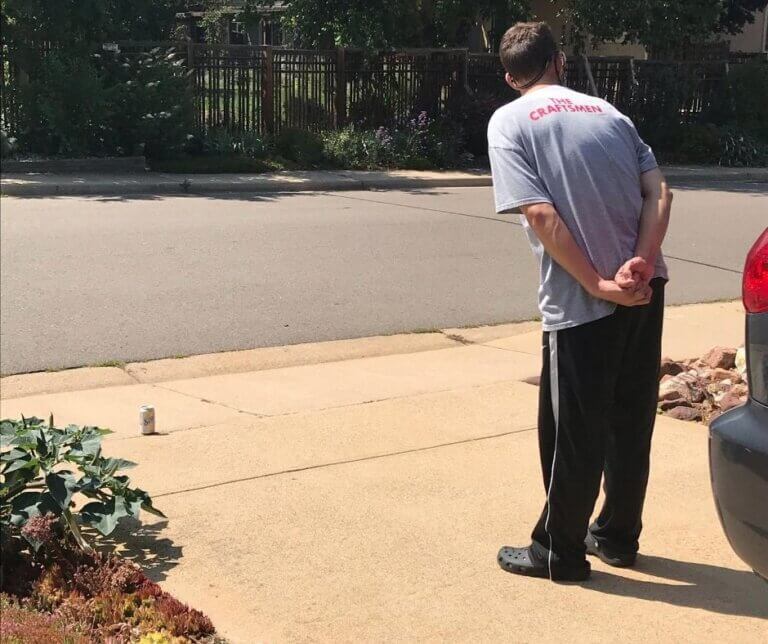 ian waiting for the mail carrier with a soda for them in the driveway