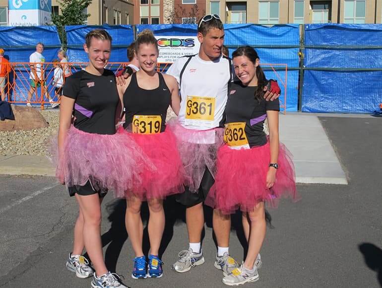 Ian and three other runners wearing pink tutus for a local race event
