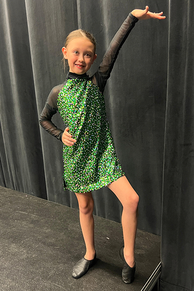 Lorelei McGee wearing a green sparkly dance costume.