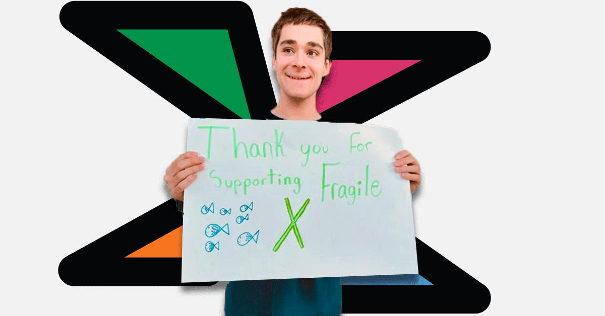 Mitch holding a sign saying Thank you for supporting Fragile X.