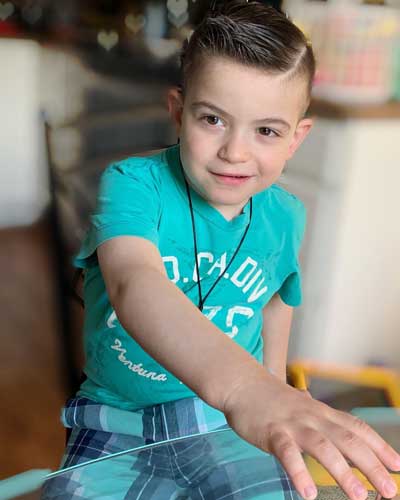 Preston Levenzon, a young boy wearing a turquoise t-shirt and a mighty spiffy hairdo.