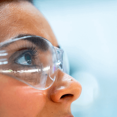 Woman in protective glasses looking to the right and up 