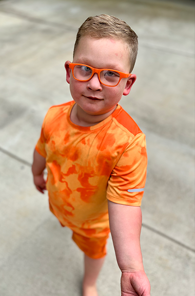 Waylon Maples wearing orange short, t-shirt, and eyeglasses.
